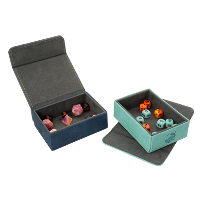 open night blue and turquoise resistant denim-like caratex tokencove boxes for dice, tokens and counters or sleeved tcg trading cards filled with various dice and with removable, magnetic cover clipped to side and placed under bottom