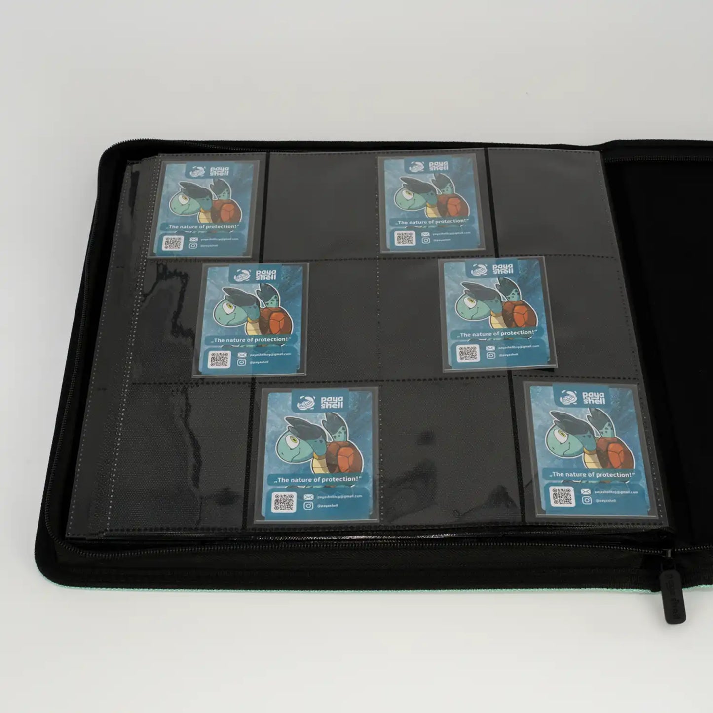 inside view with cards of open zip-up album binder with 24 sideloading pockets per page, 4x3 layout, 20 double-sided, black pages, 3 extra mesh pockets for toploaders, magnetic card holders and sleeves and secure zipper for 480 standard and japanese size tcg trading cards